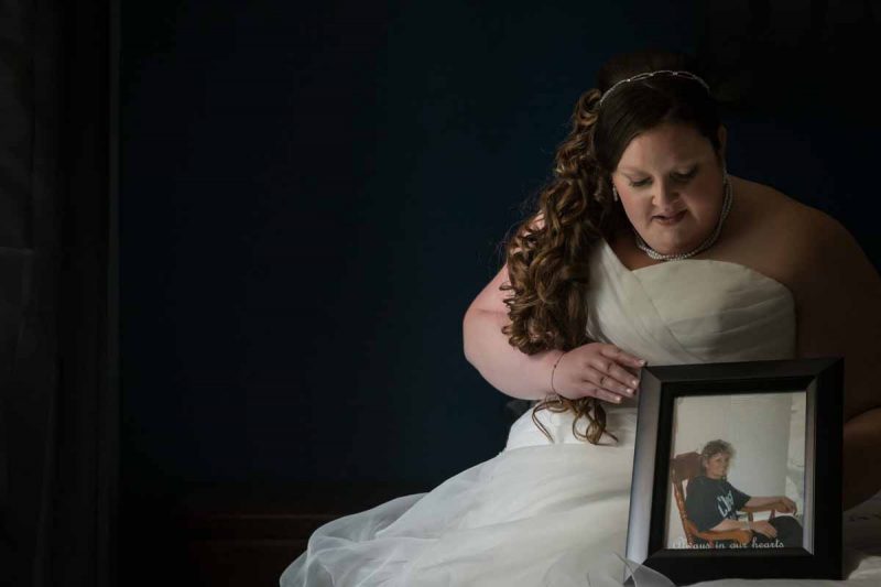 Bride holding photo frame of her mom