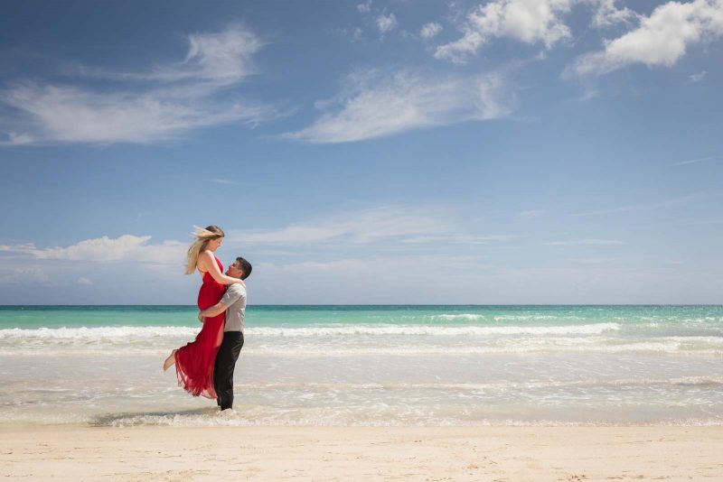 Bride lifted by groom on the beach