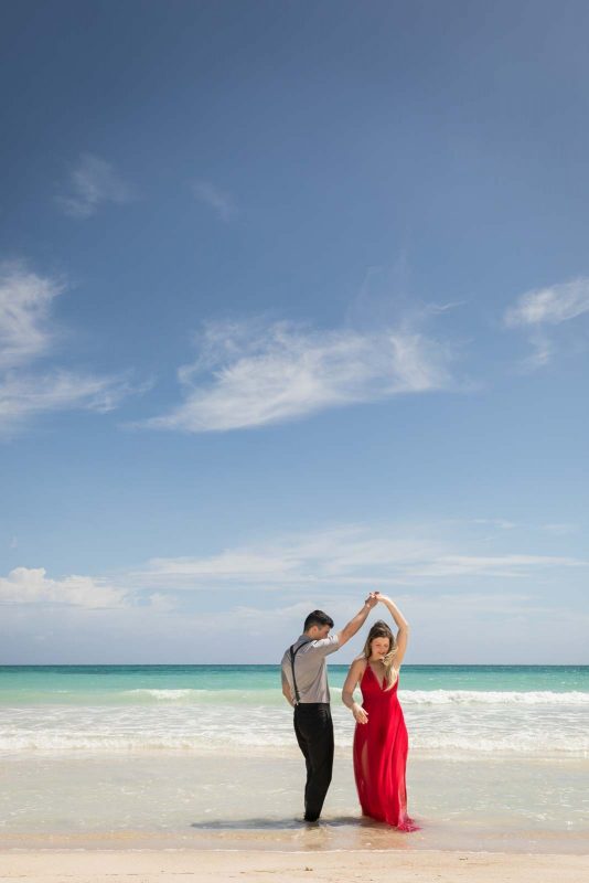 Newlyweds twirling on beach