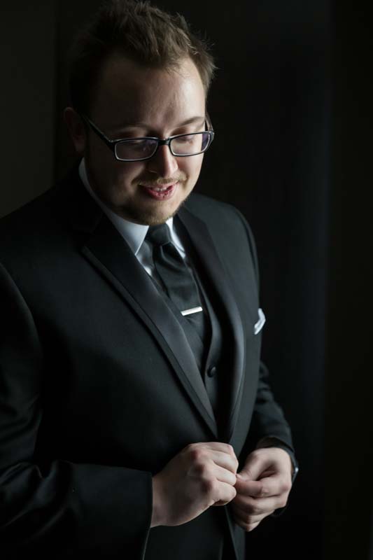 Groom buttoning suit