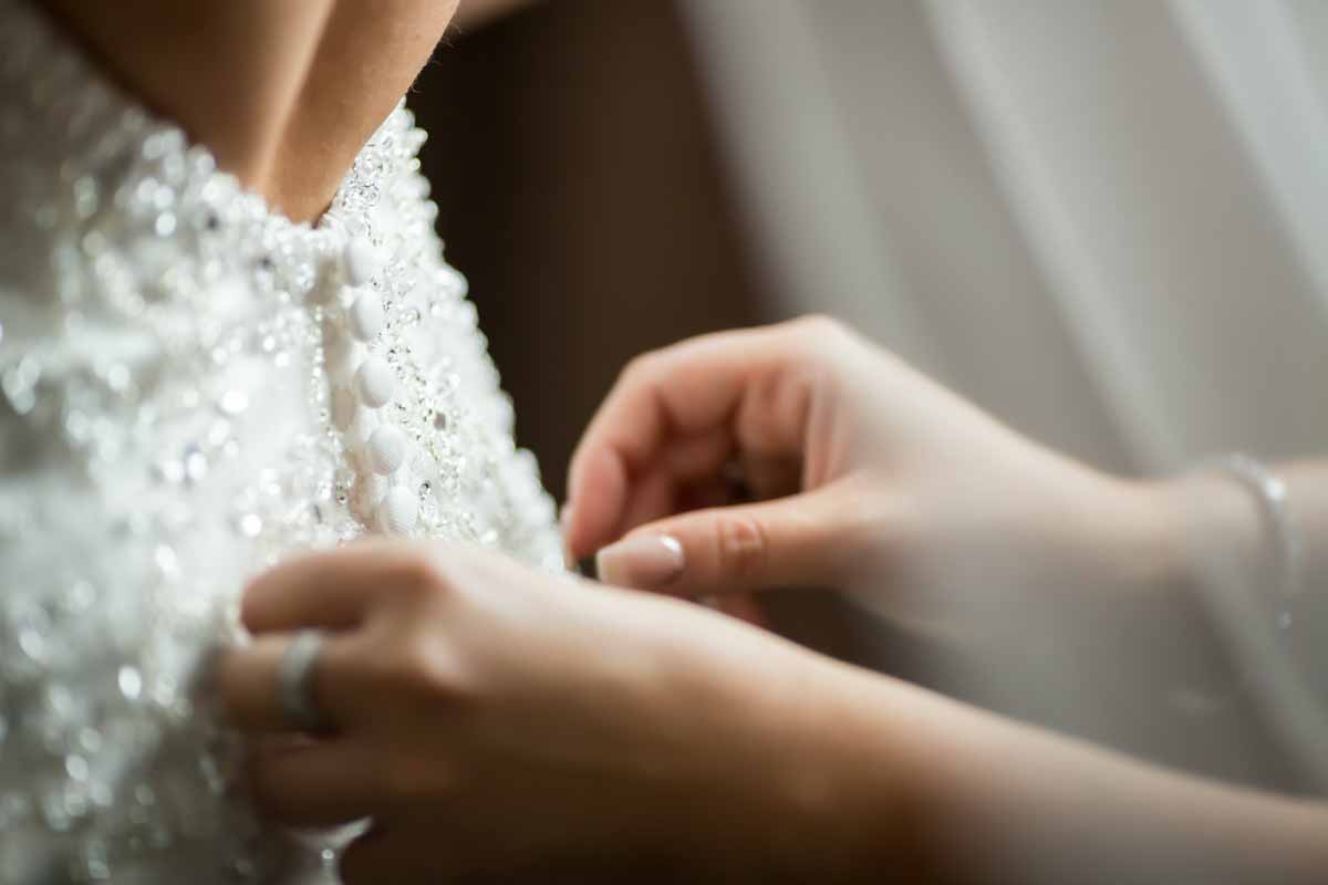 Buttoning bride's dress