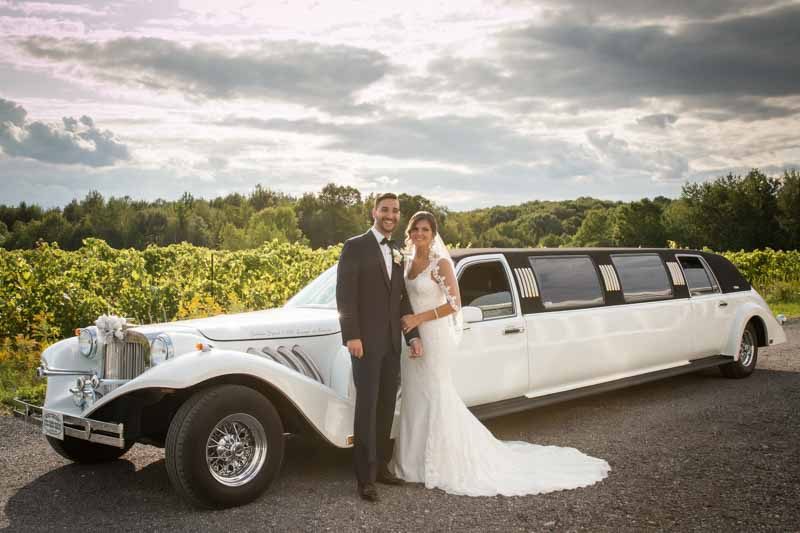Newlyweds in front of limousine